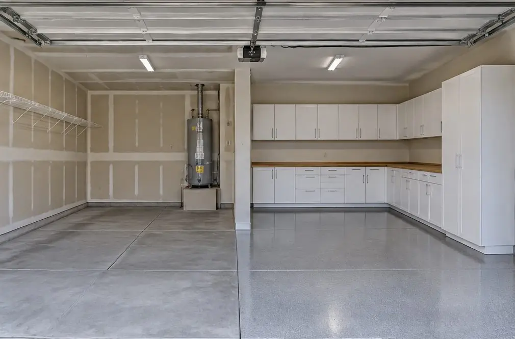 Illustration: a bare builder-grade three-car garage in a Murrieta, CA tract with taped drywall, one wire shelf and a water heater, next to a view of the same walls with white ready-to-assemble cabinets in an L-shape